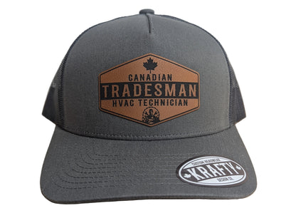 Gray cap with 'Canadian Tradesman HVAC Technician' logo on a wooden surface