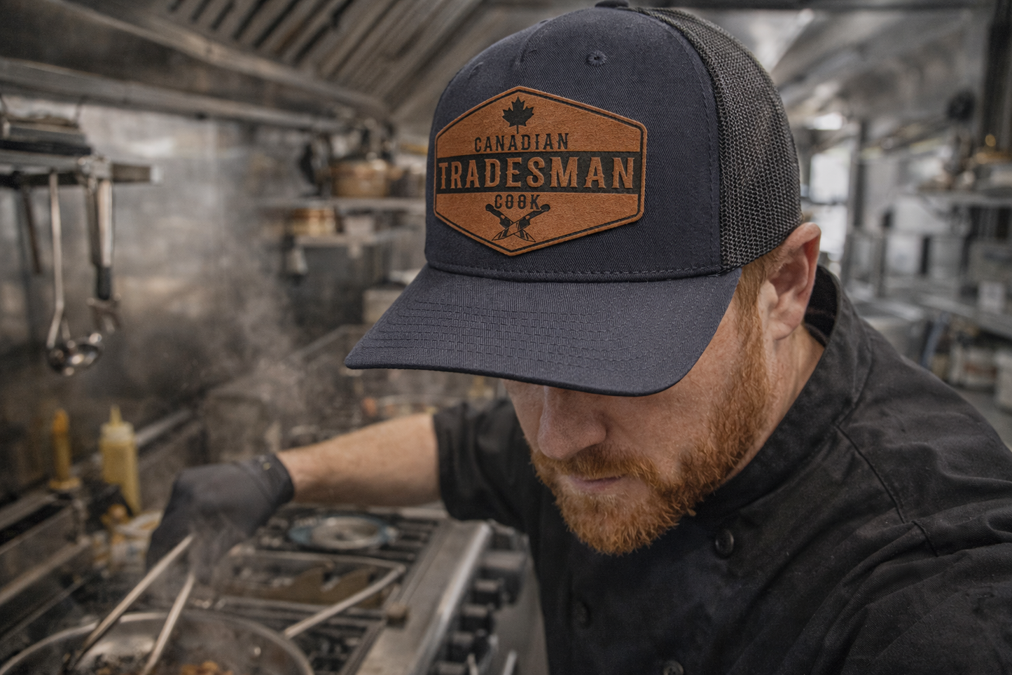 Person wearing a 'Canadian Tradesman' cap in a kitchen setting