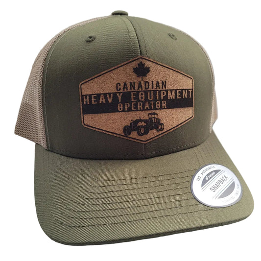 A green and beige trucker hat with a patch that reads 'Canadian Heavy Equipment Operator' and an emblem of a maple leaf and a gear.