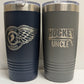 Two tumblers, one navy and one gray, with engraved text and logos on a white background.